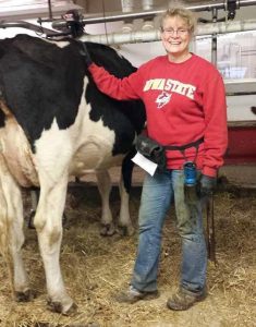 Madeline Schultz standing next to a Holstein cow 